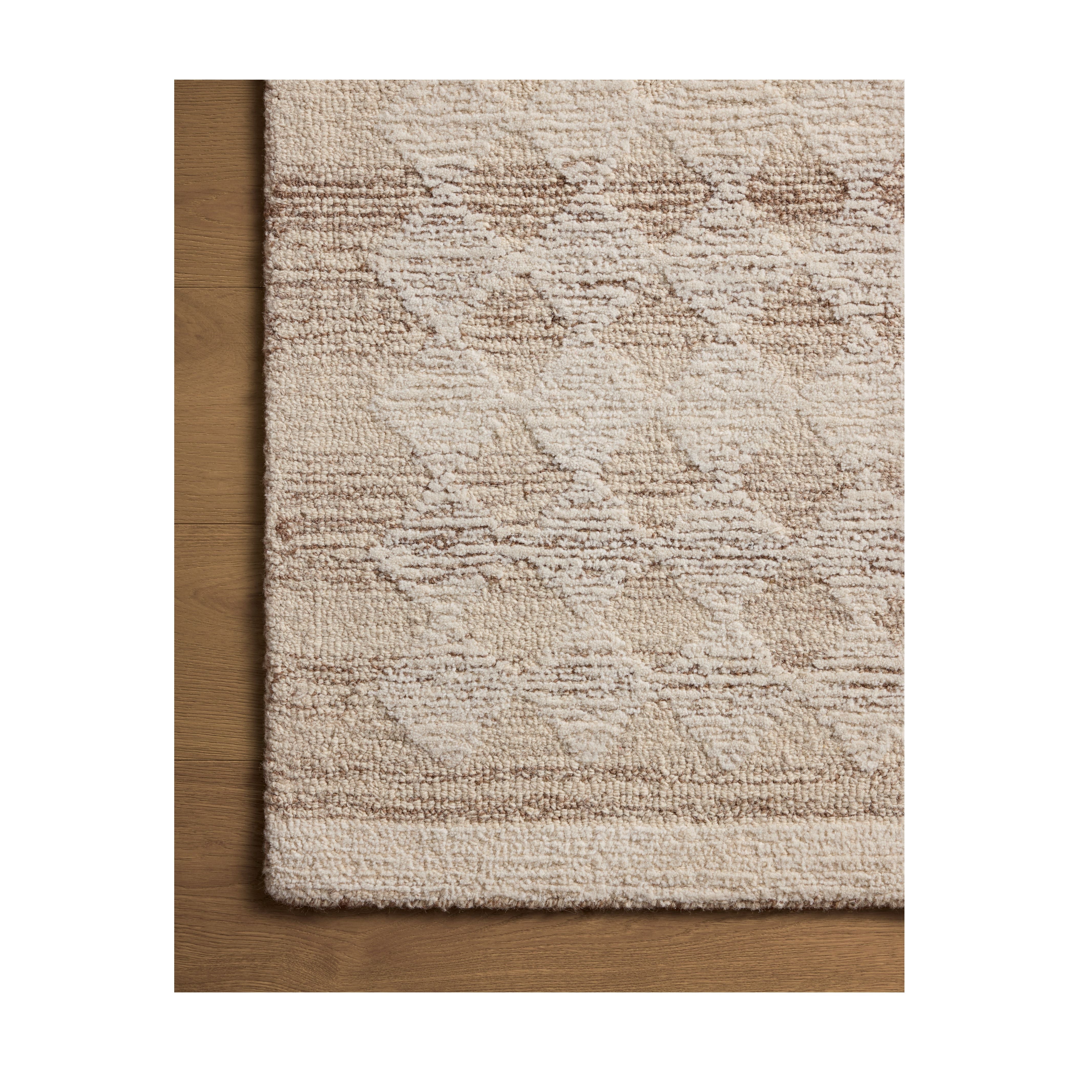 Rae Natural Ivory Rug close up of corner of rug on wood floor
