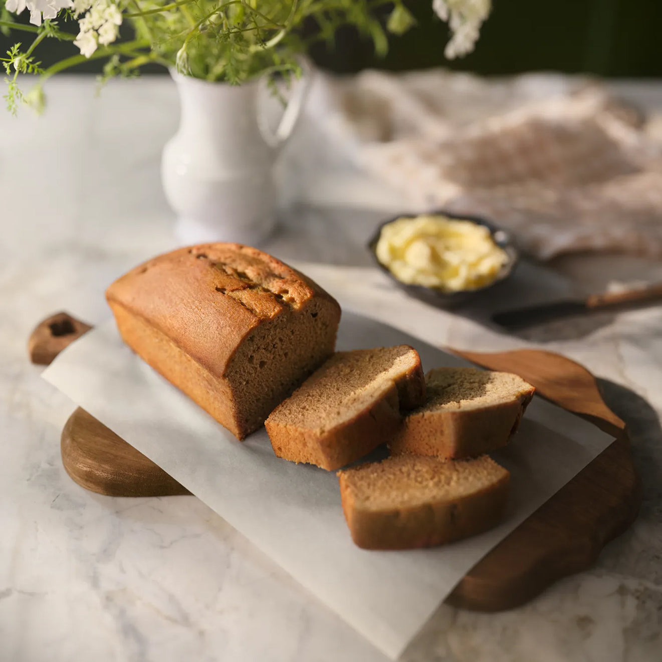 A sliced loaf of Magnoliass Table After School Banana Bread on a cutting board.