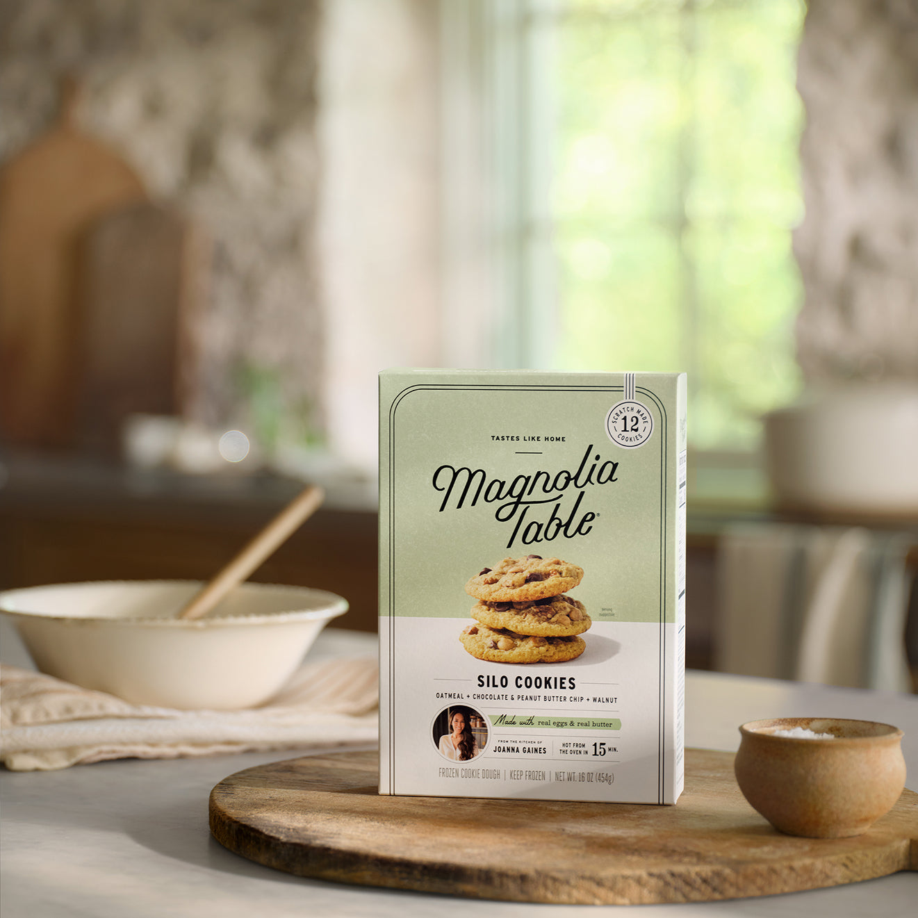 Box of Frozen Magnoliass Table Silo Cookies on a table with a mixing bowl in the background.