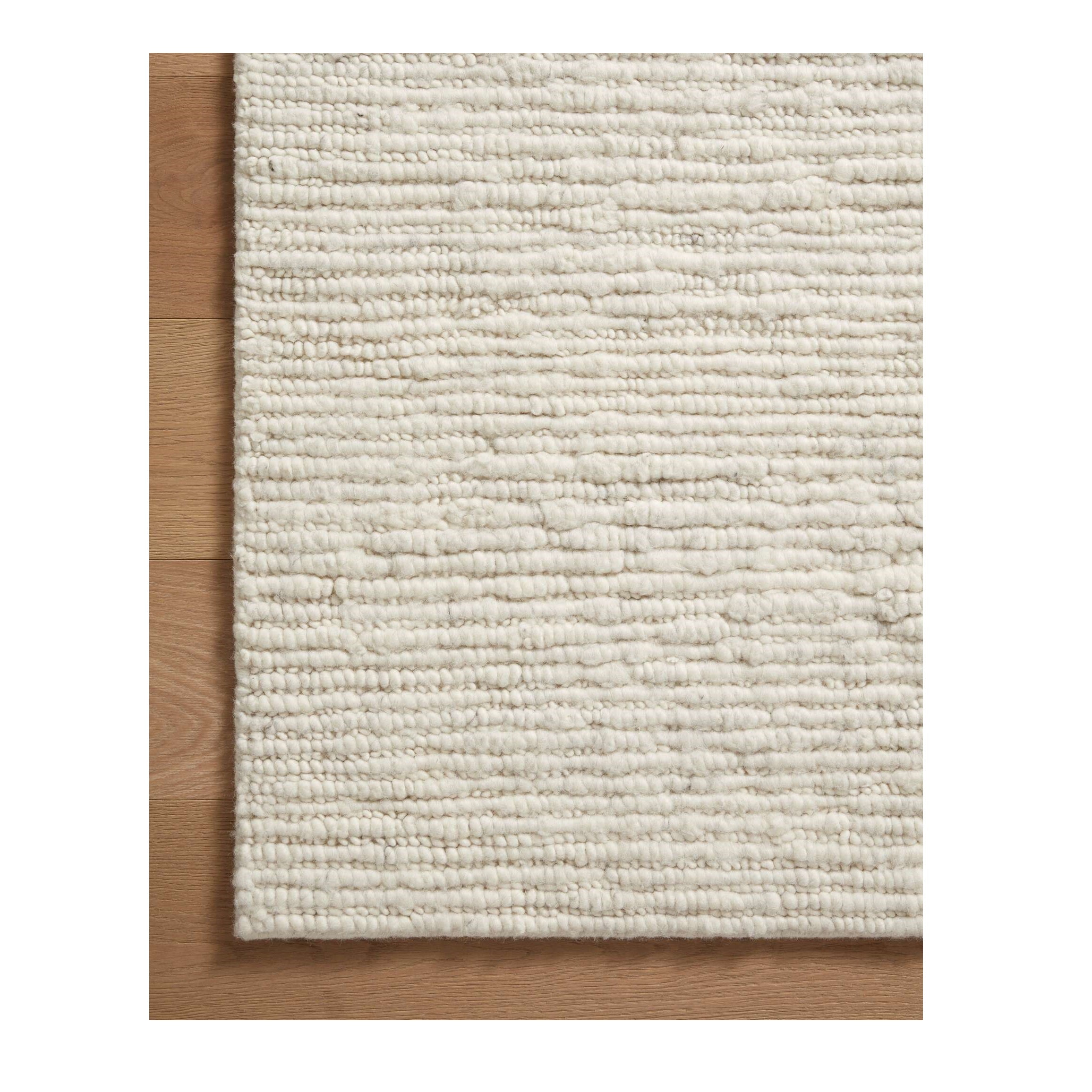 Ava Dove Ivory Rug close up of corner of rug on wood floor
