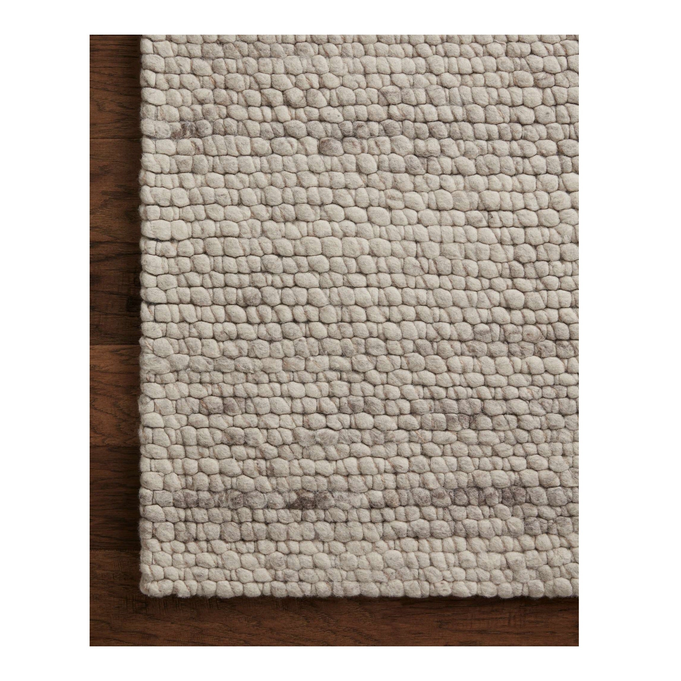 Caroline Natural Rug close up of corner of rug on wood floor