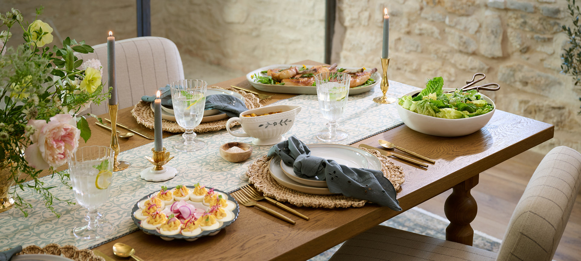 Elegant dining table setting with plates, glasses, and decorative elements.