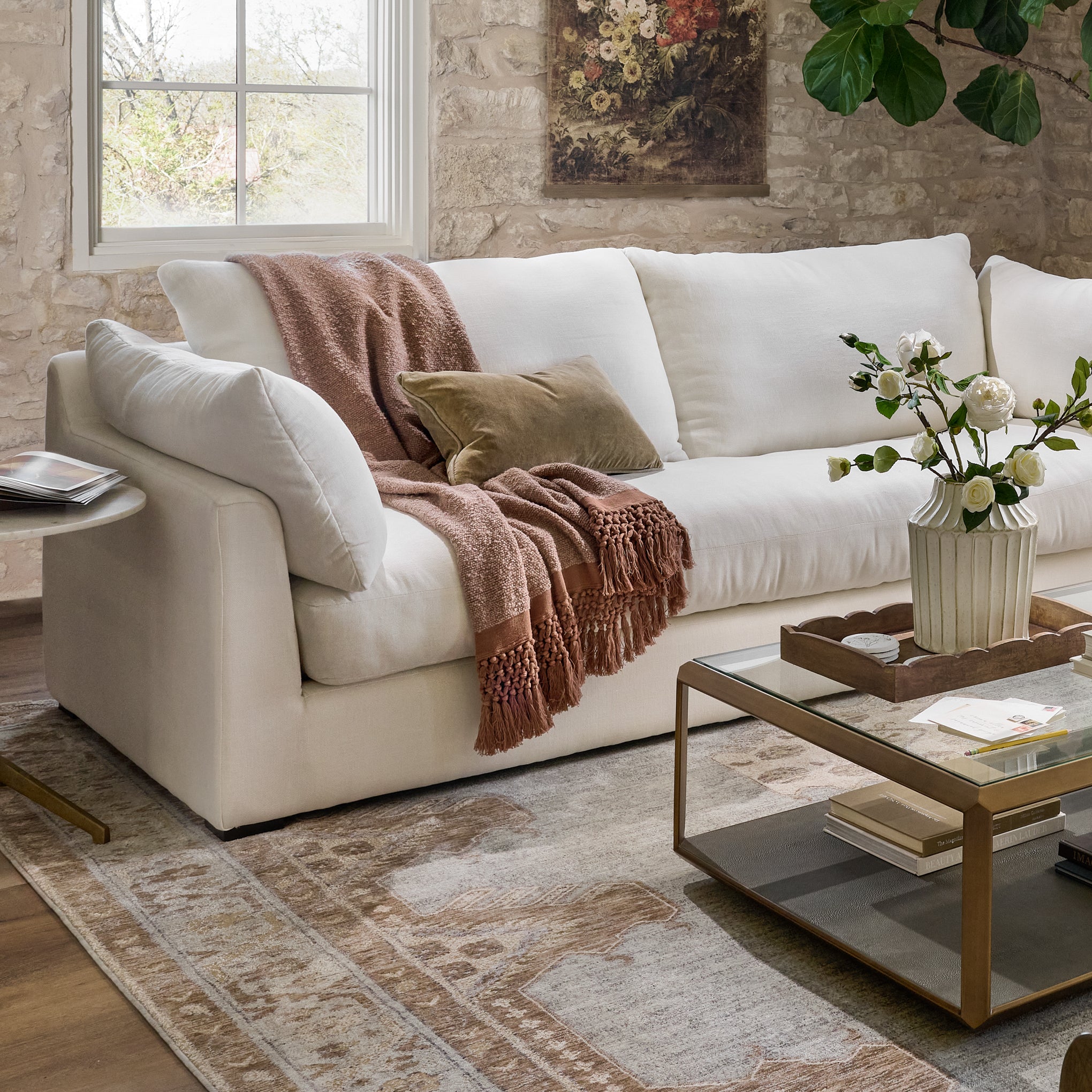 serene sofa in a living room with a glass dining table and throw blanket