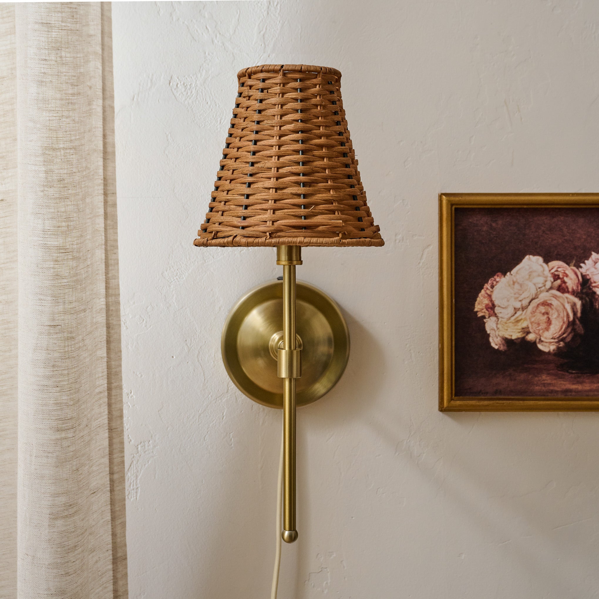 Rattan Plug-In Wall Sconce shown on wall with wall art