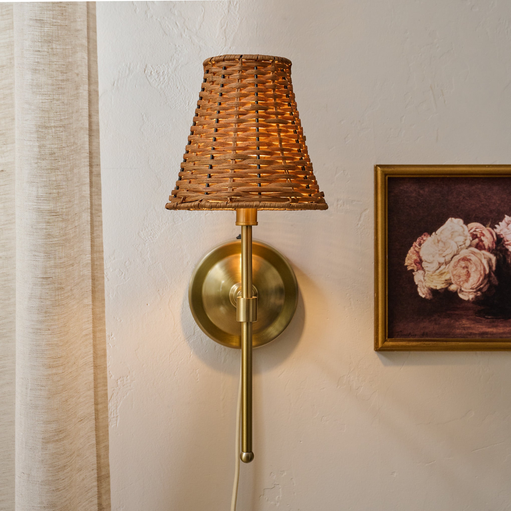 Rattan Plug-In Wall Sconce shown on wall with wall art