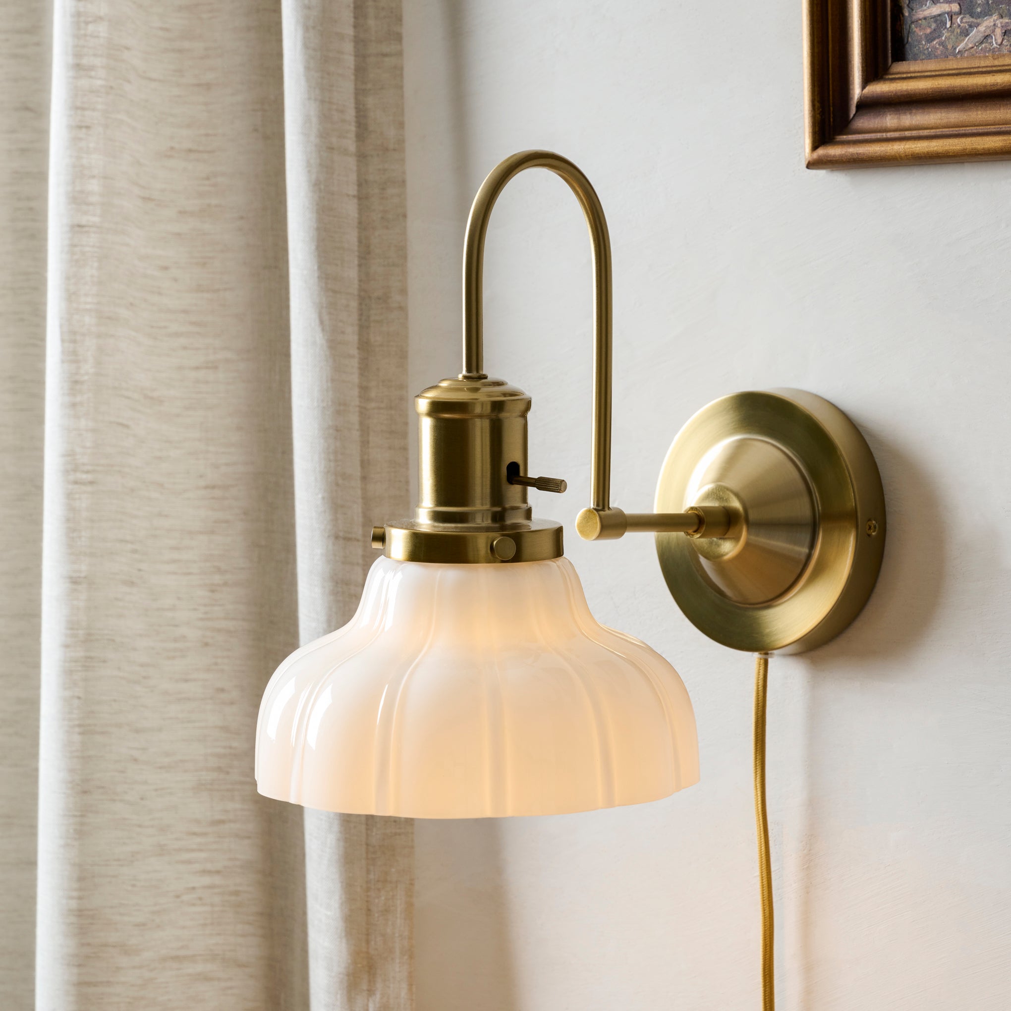 Polly Milk Glass Plug-in Sconce shown on wall
