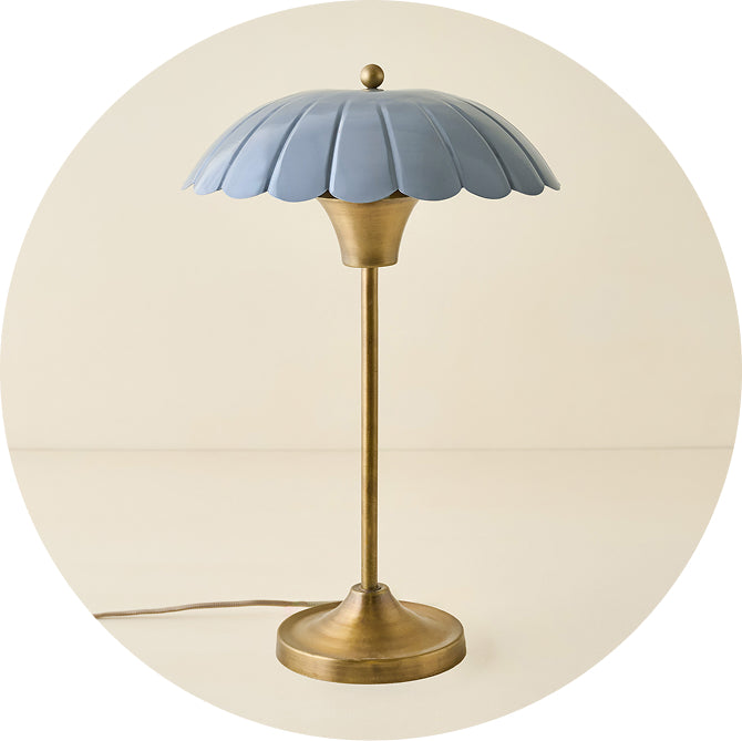 Table lamp with blue floral shade and brass base on a beige background
