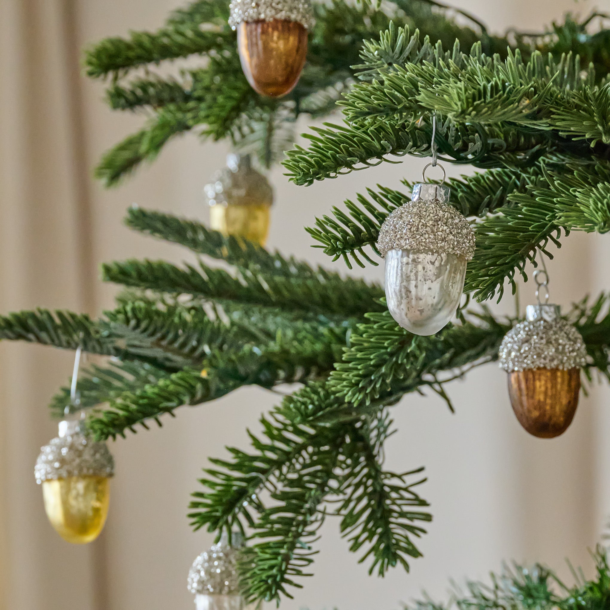 Glass Acorn Ornament, Set of 12 shown hung on tree