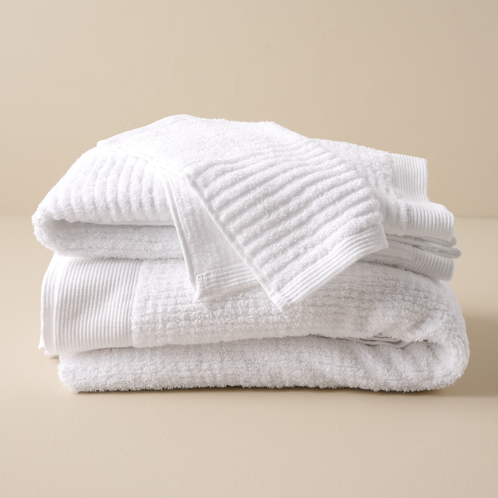 stacked White Textured bath towels and washcloth
