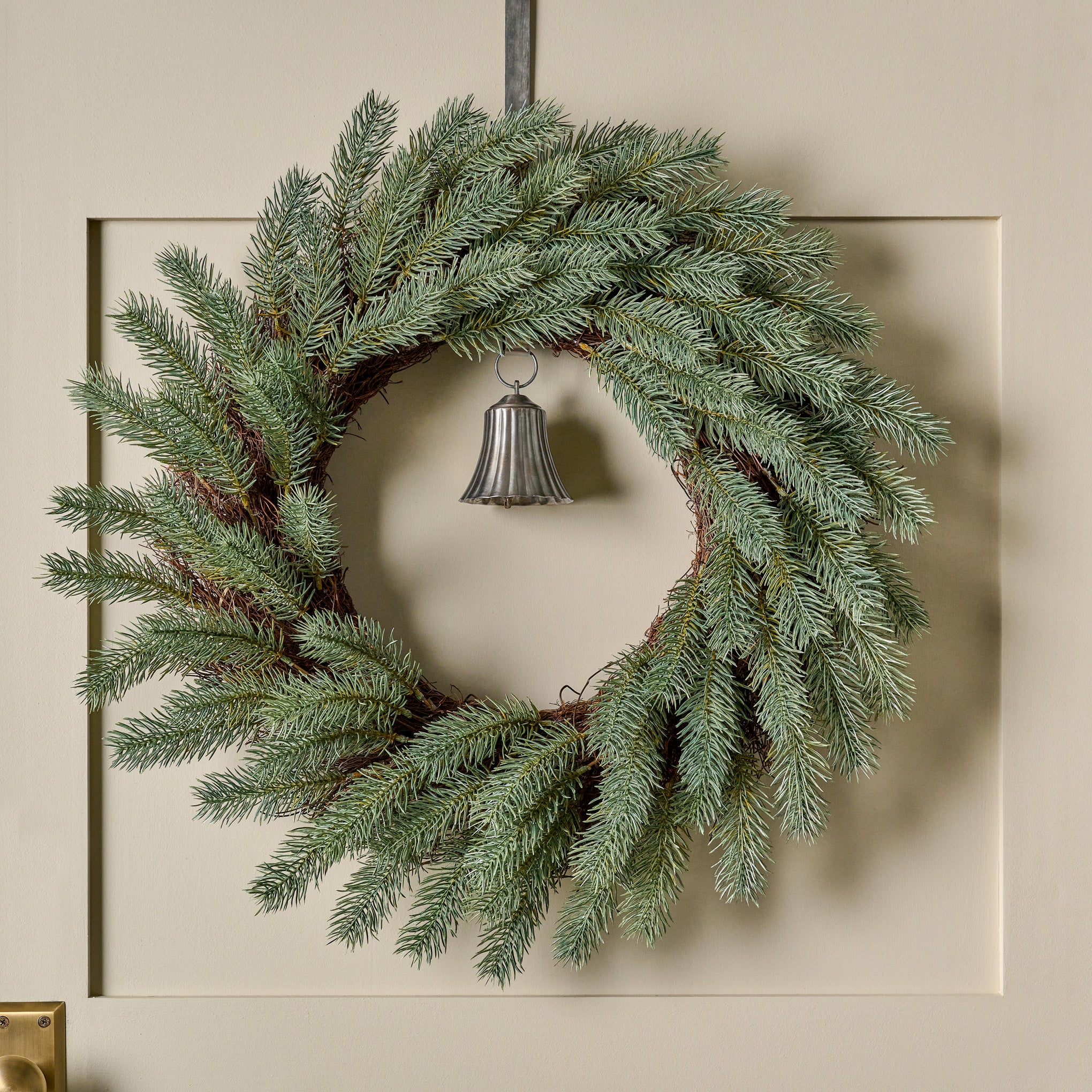 Real Touch Silver Pine Wreath shown hung on door with bell