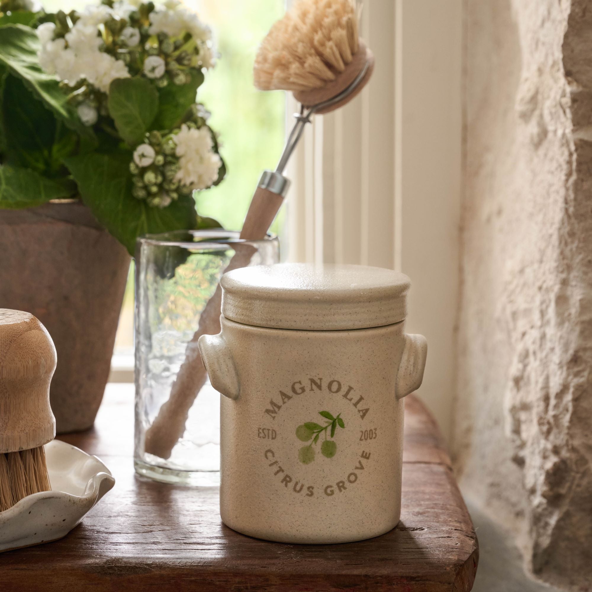 Magnoliass Citrus Grove Candle with lid on wooden riser
