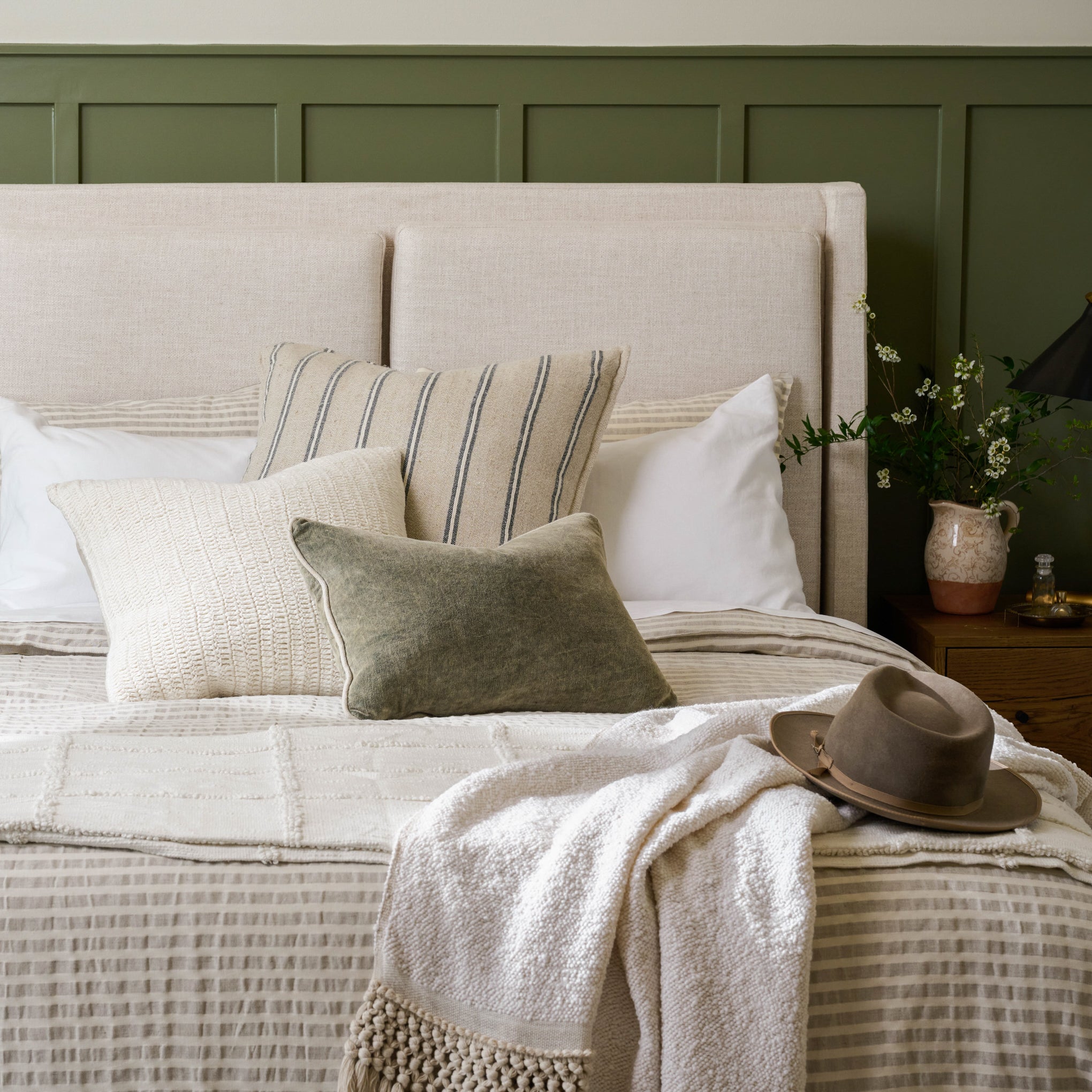Angora Tassel Throw on the foot of a bed with a hat on top