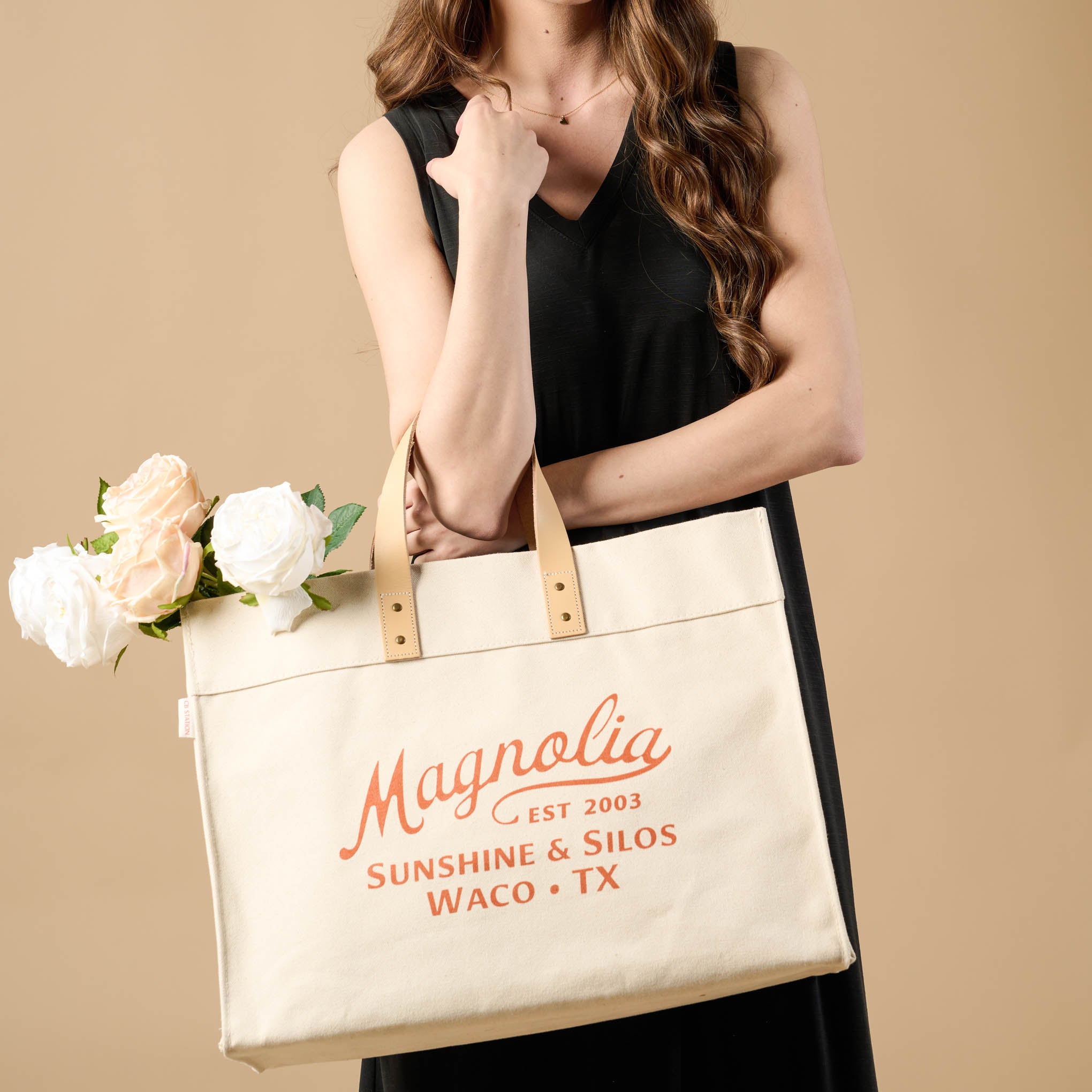 Magnoliass Cora Script Large Canvas Tote with florals sticking out of the bag