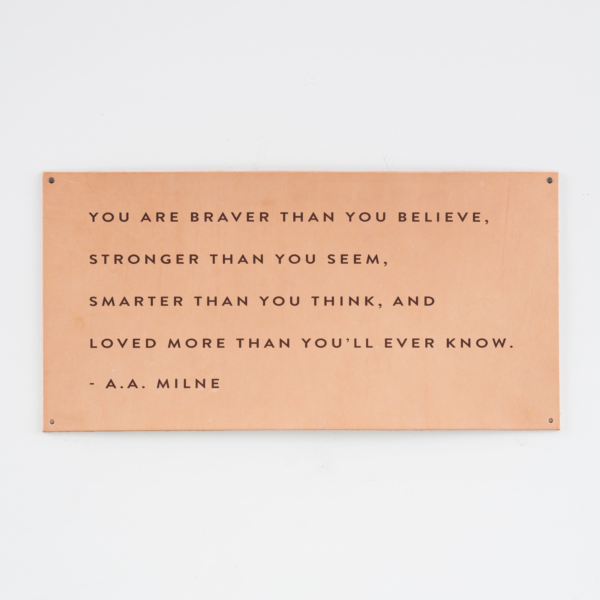 leather wall sign with a quote by a.a. milne