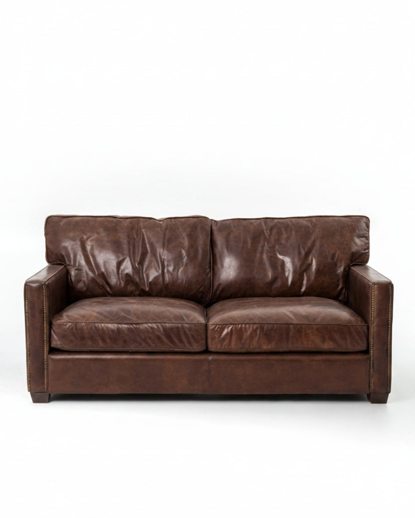medium brown leather sofa with nailhead arms