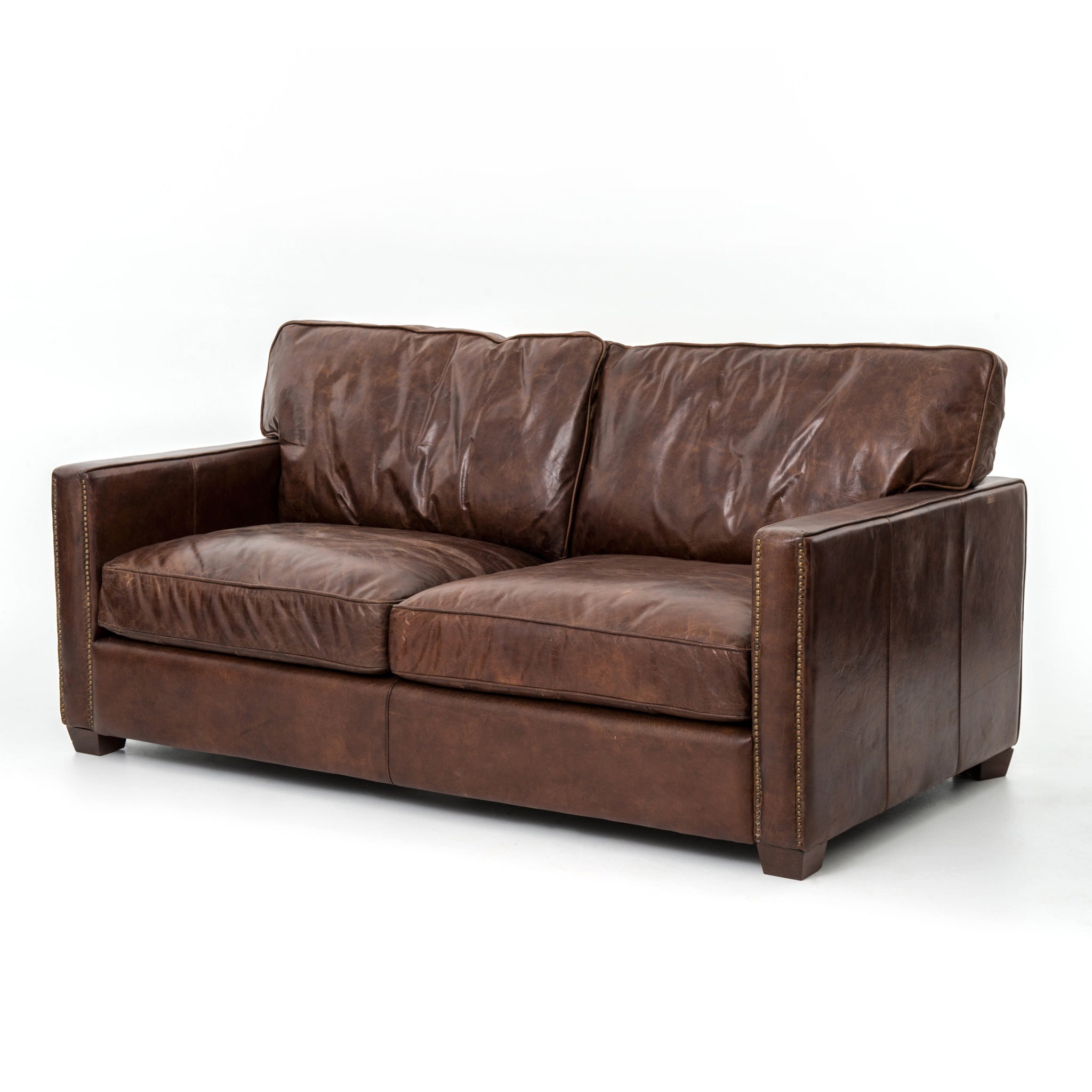 medium brown leather sofa with nailhead arms