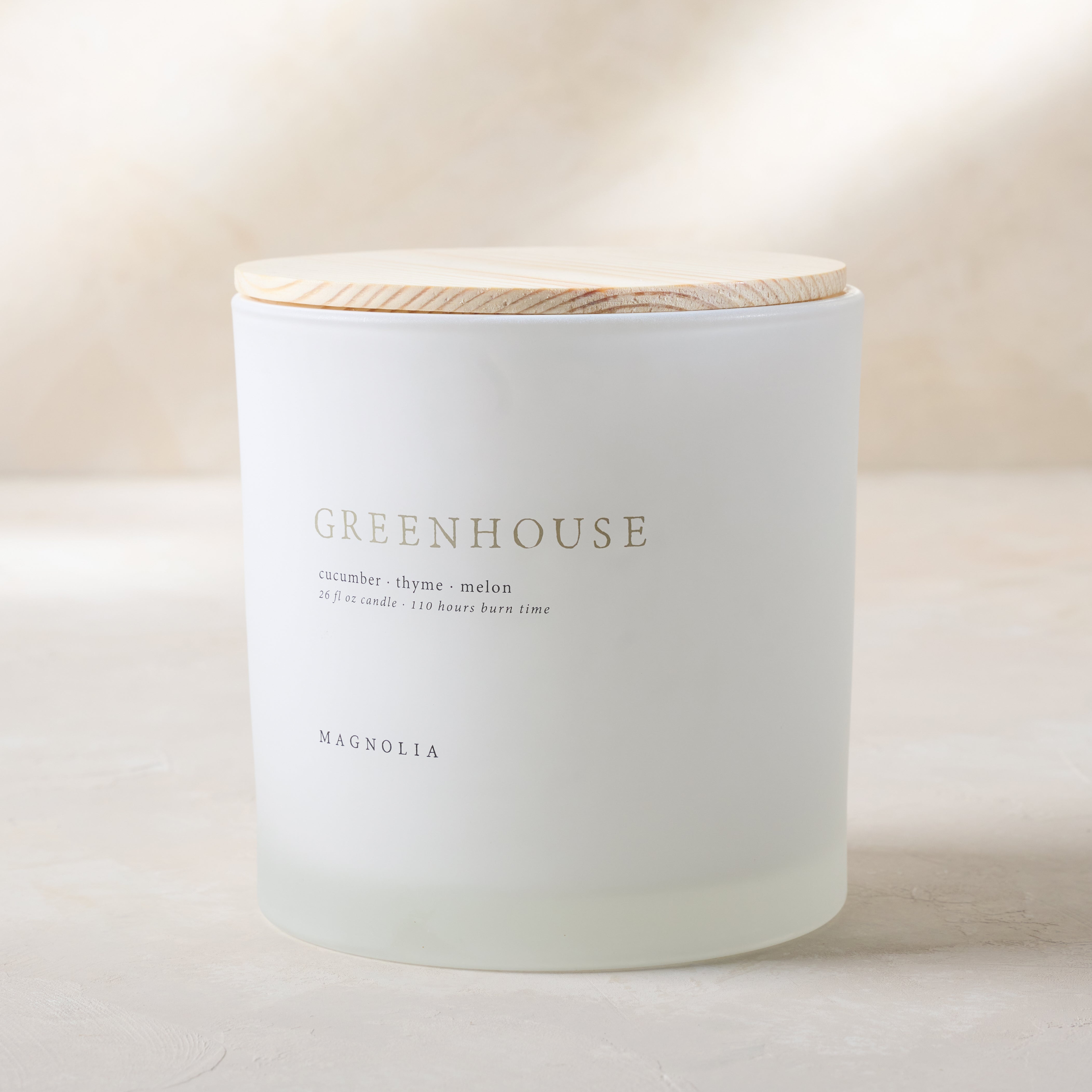 Magnoliass greenhouse candle with wood lid notes scents of cucumber thyme and melon
