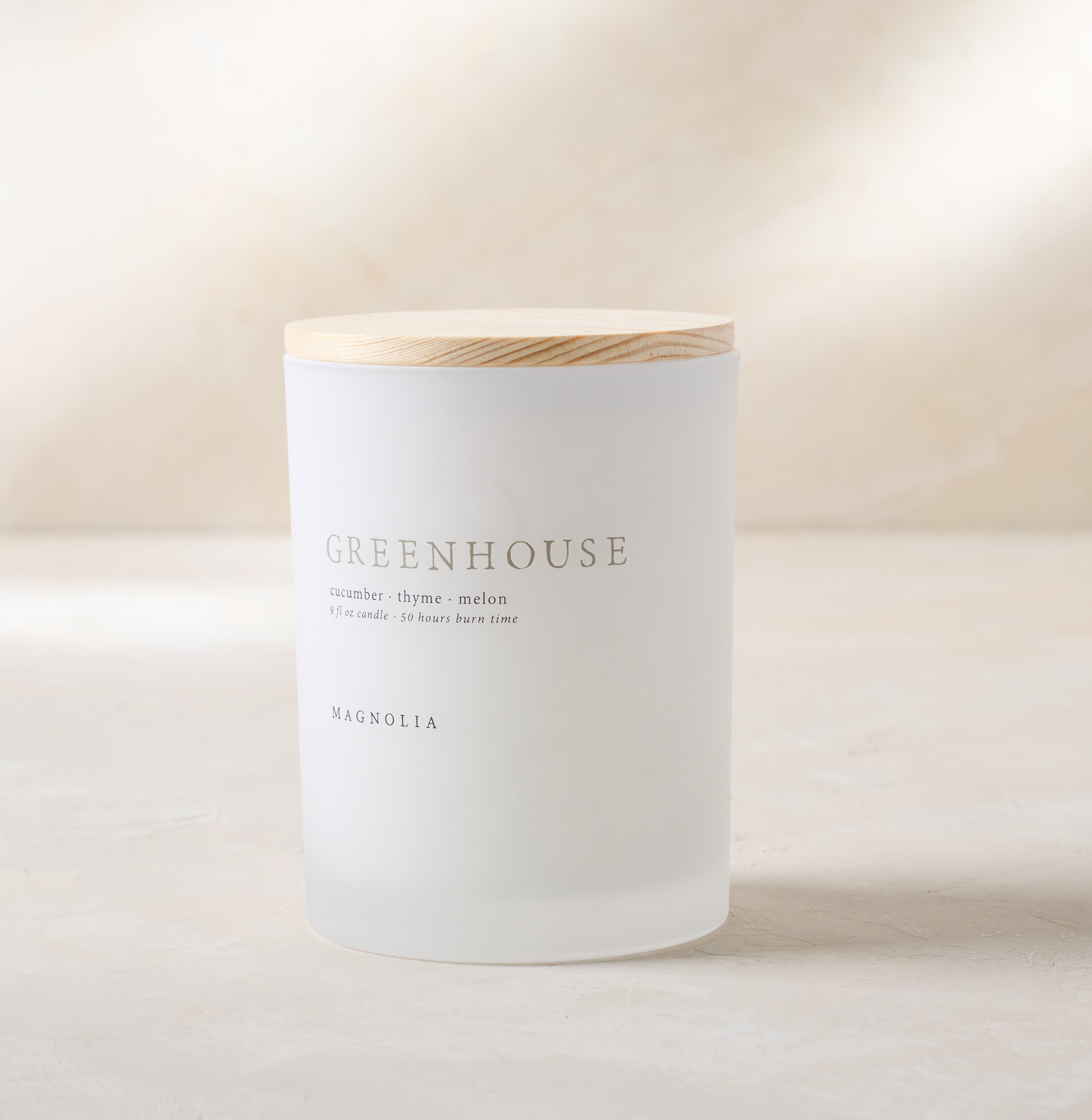 Magnoliass greenhouse candle with wood lid notes scents of cucumber thyme and melon