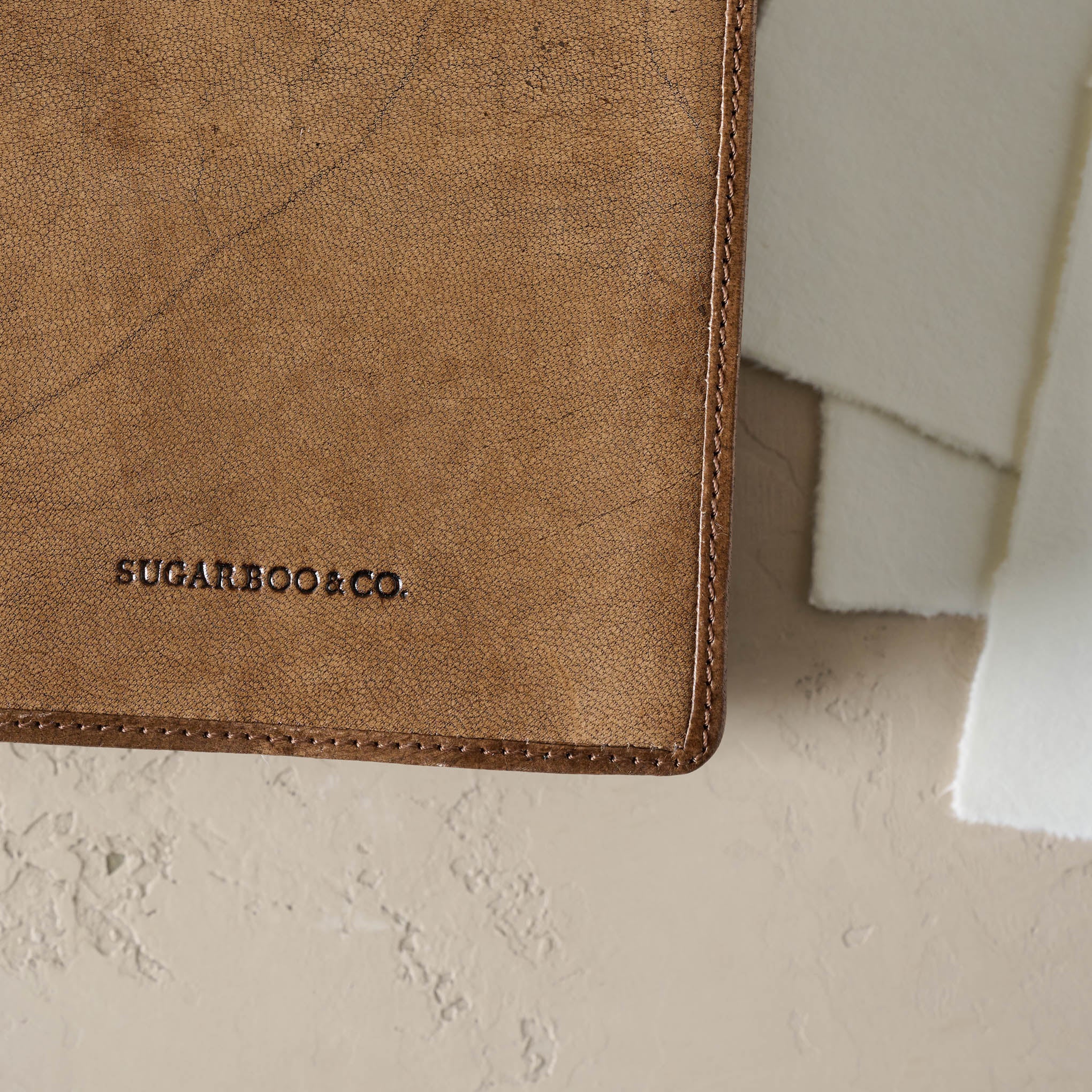 Close up of Sugarboo & Co text branding at the bottom right corner of the front cover of notebook. 