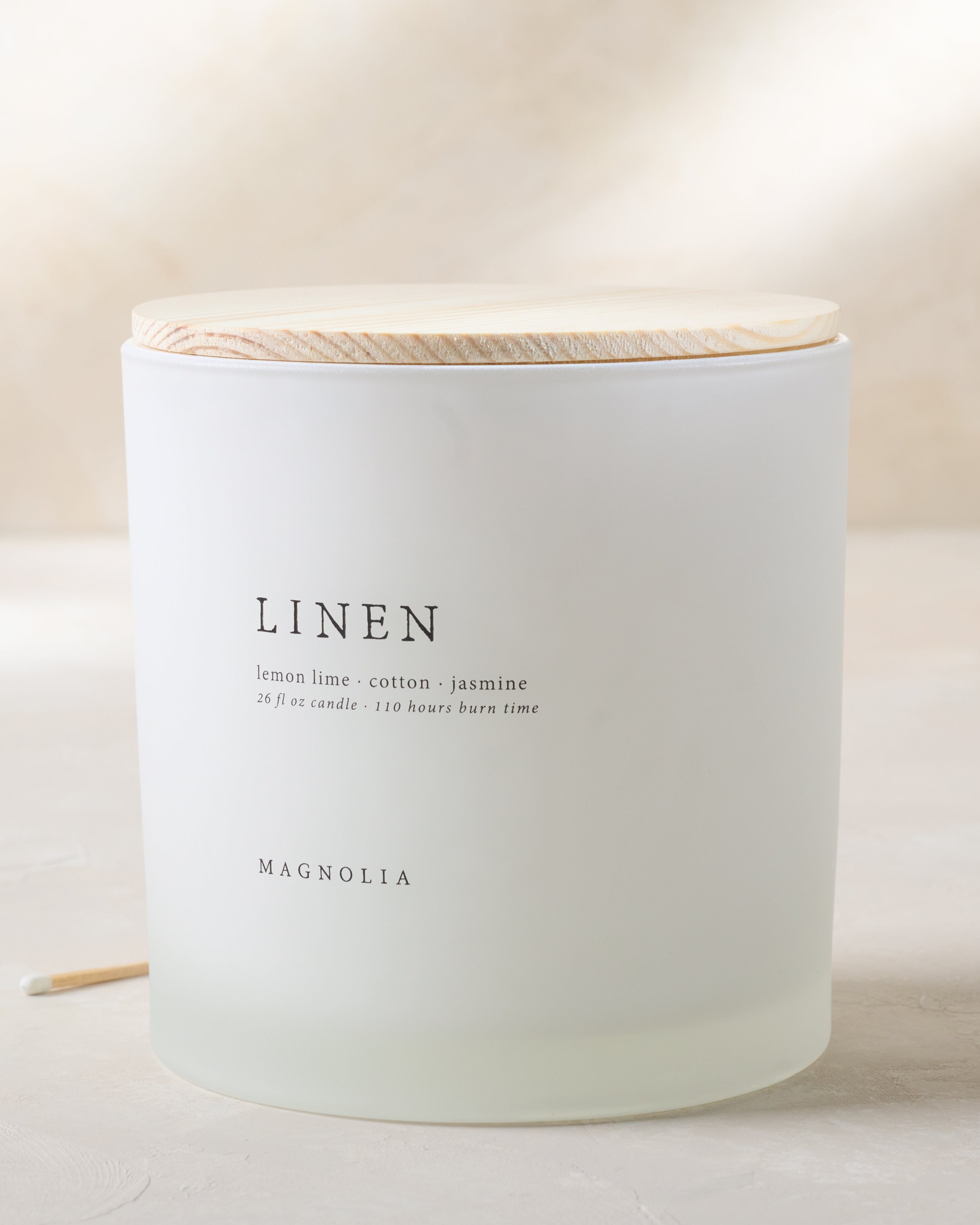 Magnoliass linen candle with wood lid notes scents of lemon lime cotton and jasmine