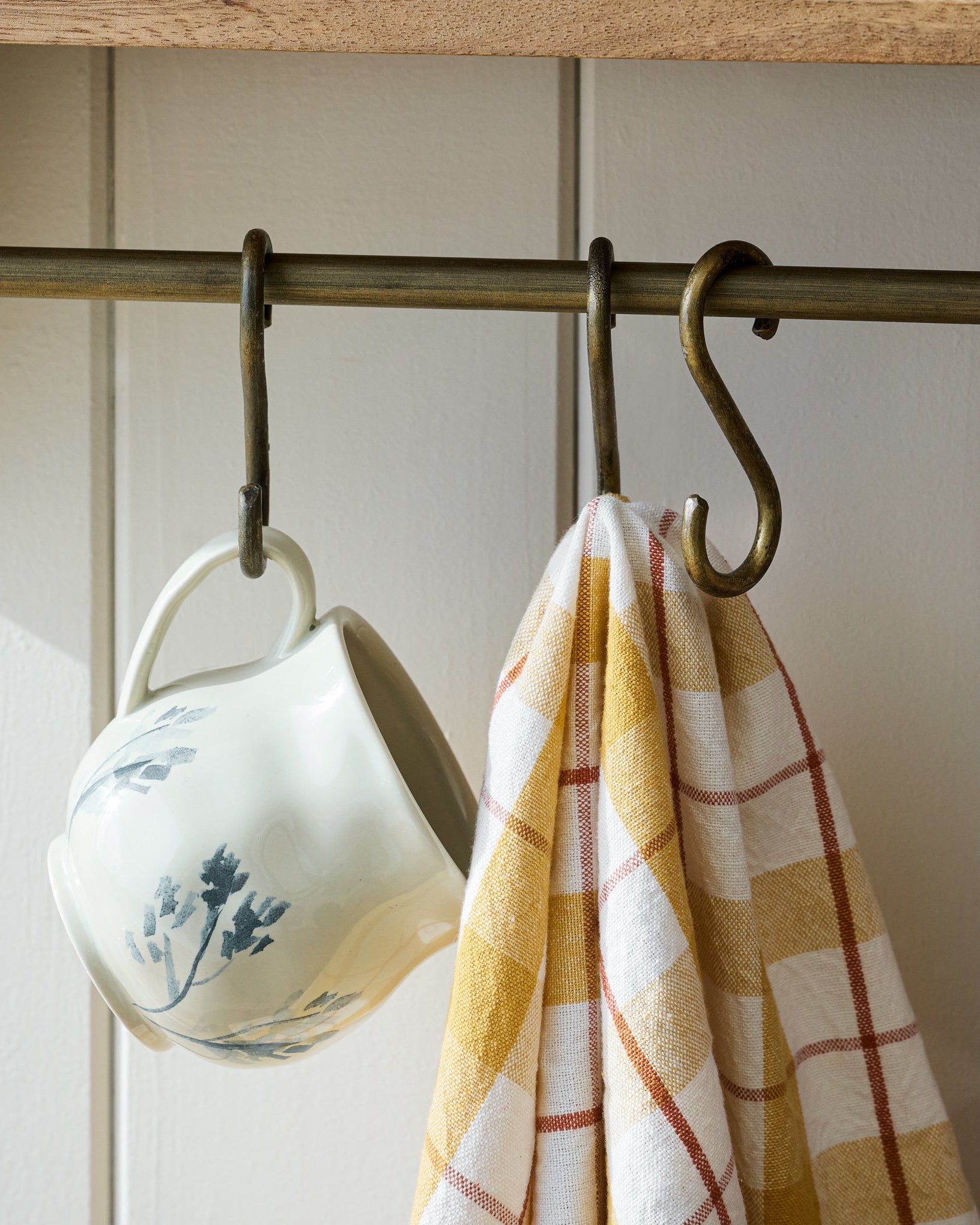 Hannon Wood and Brass Display Shelf hooks holding mug and a napkin