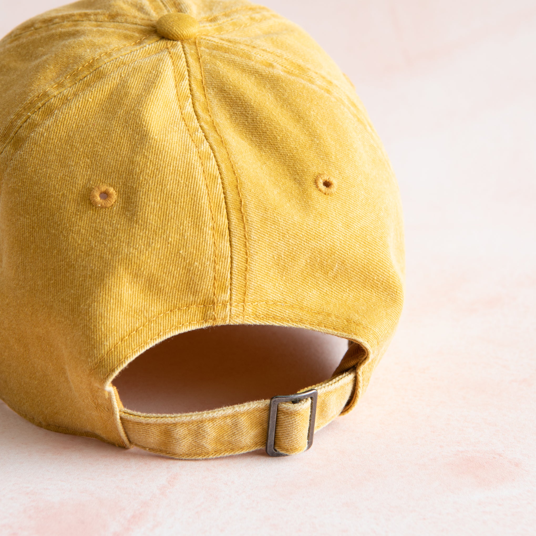 yellow ball cap with "Magnolia Est 2003" in cursive script