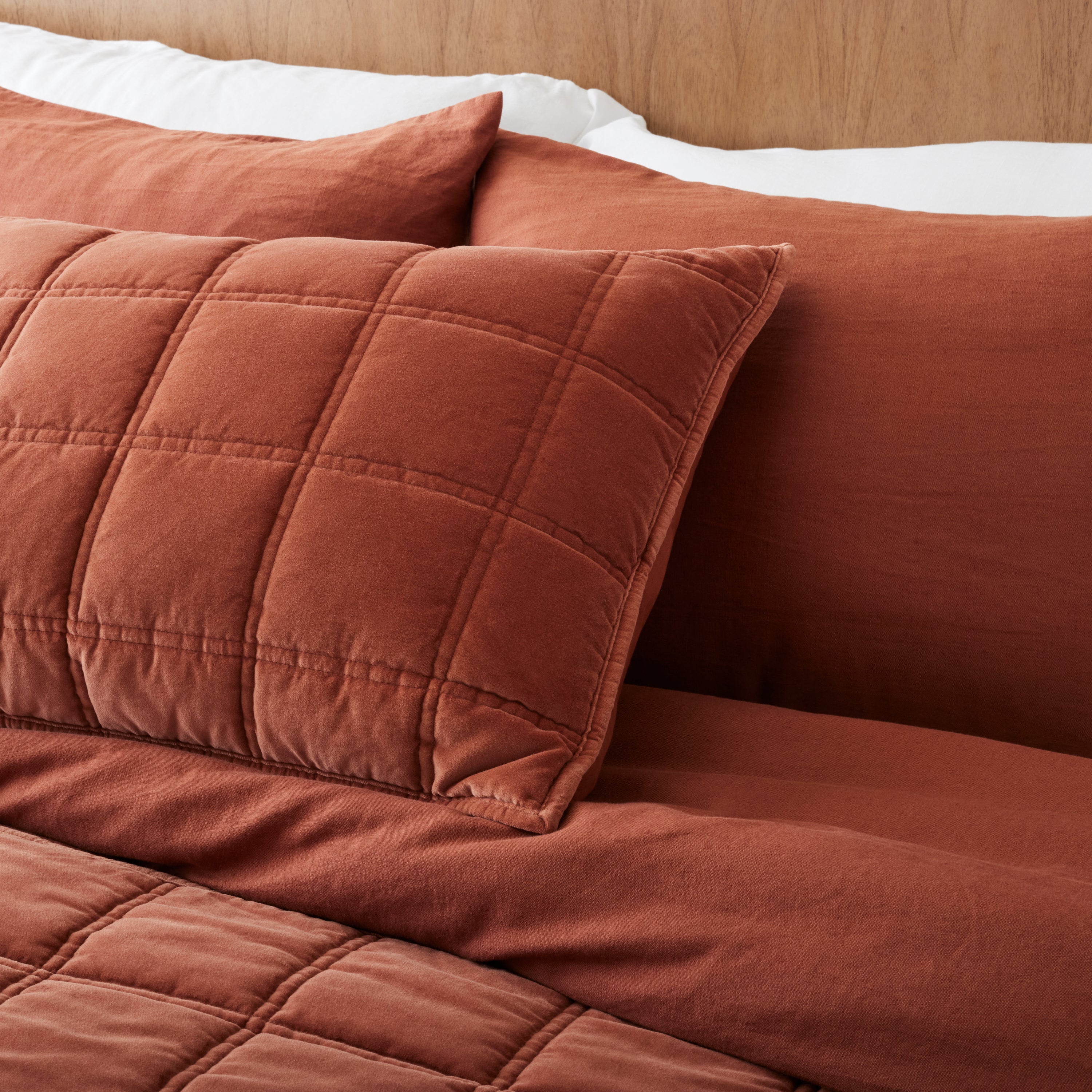 Weekend velvet sham in rustic clay on a made bed