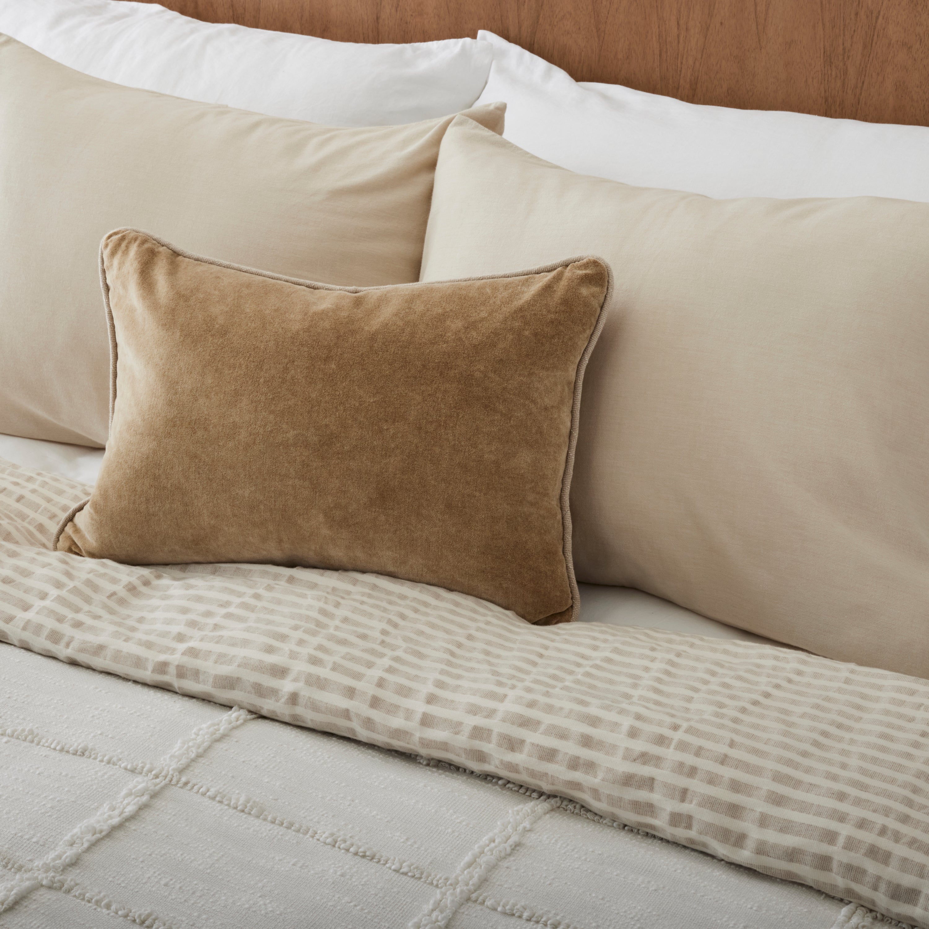 Angora + Oatmeal Stripe Linen Cotton Duvet on a made bed with a throw pillow