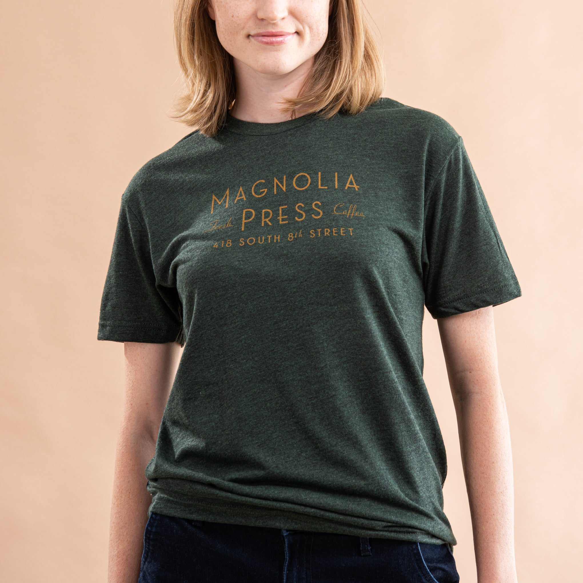 emerald green t-shirt with Magnoliass press coffee logo in gold across chest