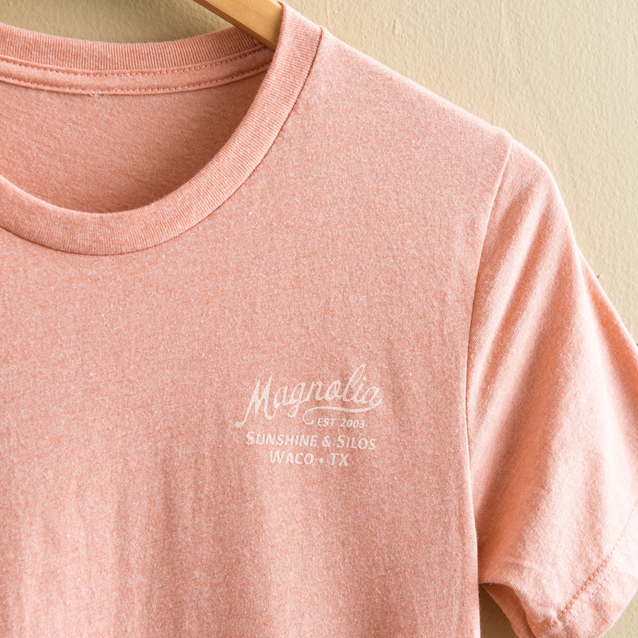pink-coral t-shirt with "magnolia est 2003" in a cursive script font